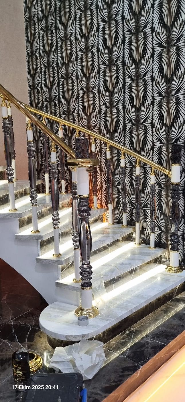 Gold küpeşte ve füme kristal dikmelerle LED aydınlatmalı mermer merdiven